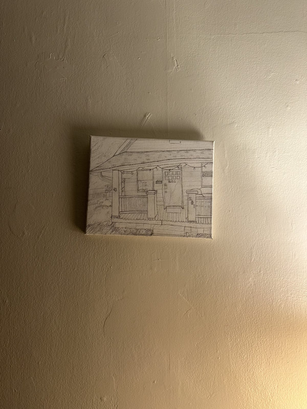 A drawing of a house on canvas on a blank wall